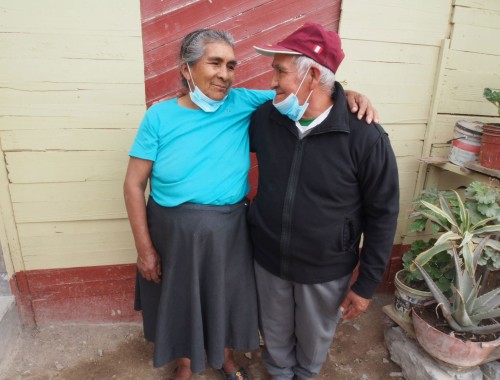 Pareja de esposos, un hombre y una mujer mayores mirándose y sonriendo, parte de la comunidad Los Jazmines en la Ensenada de Puente Piedra (Lima, Perú).